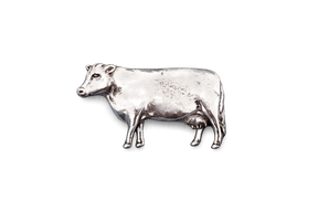 Detailed pewter dairy cow pin badge with butterfly clutch fastening on a white background.