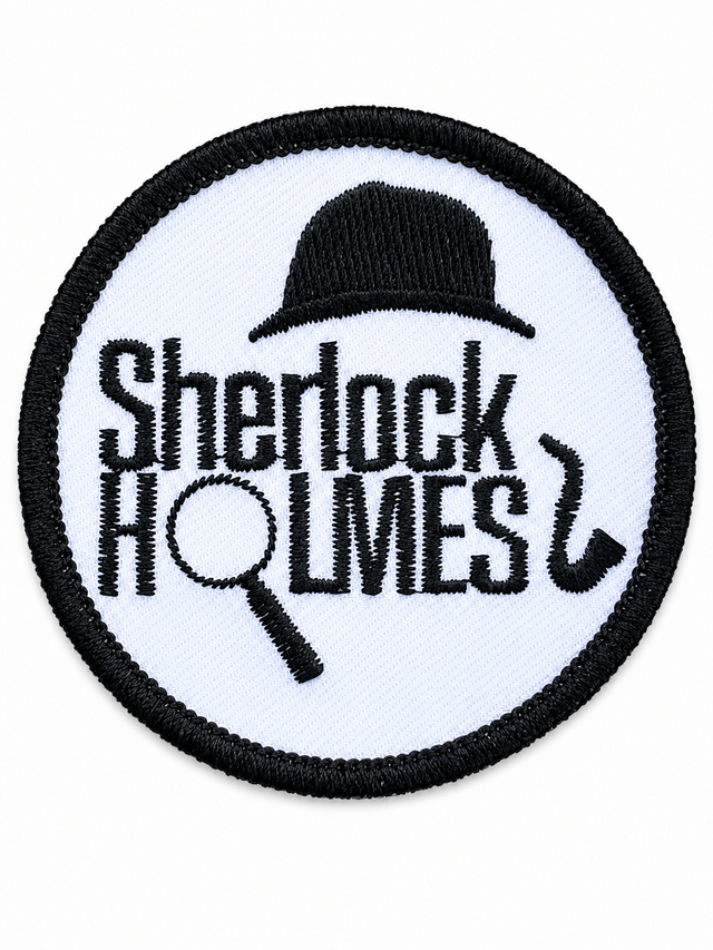 Round Sherlock Holmes embroidered patch featuring a bowler hat, magnifying glass and pipe in black on a white background with a black stitched border, suitable for iron-on or sew-on application.