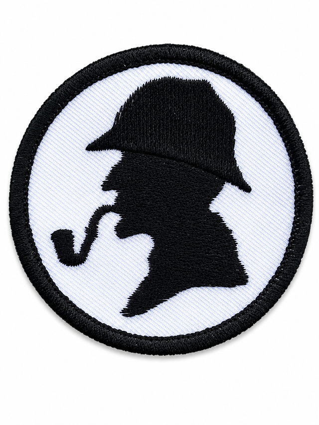 Round Sherlock Holmes silhouette embroidered patch featuring a detective profile with deerstalker hat and pipe, black stitching on a white background with a black stitched border, suitable for iron-on or sew-on application.