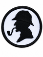 Round Sherlock Holmes silhouette embroidered patch featuring a detective profile with deerstalker hat and pipe, black stitching on a white background with a black stitched border, suitable for iron-on or sew-on application.
