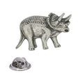 Antique silver Triceratops pewter lapel pin showing three horns, neck frill, textured dinosaur body and rear clasp