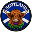 Round 80mm Scotland embroidered patch showing a shaggy Highland cow above a purple thistle, with a white Saltire on blue and SCOTLAND lettering, finished with a black border.