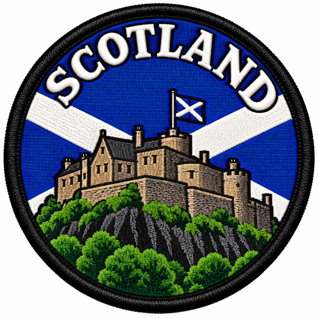 Round 80mm Scotland embroidered patch showing a stone castle on a rocky hill flying a Saltire, with a blue and white Saltire background and SCOTLAND lettering, finished with a black border.