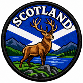 Round 80mm Scotland embroidered patch showing a brown stag with large antlers beside a loch and mountains, with a Saltire and SCOTLAND lettering, finished with a black border.