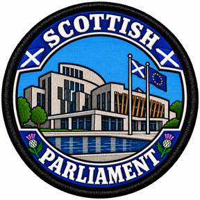 Round 80mm embroidered patch showing a stylised Scottish Parliament building with Scottish and European flags, thistles and SCOTTISH PARLIAMENT lettering, framed by a black border.