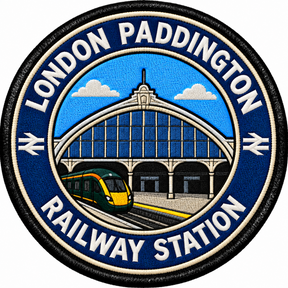Round 80mm embroidered patch showing a green passenger train beside a stylised Paddington station facade with an arched glass roof, finished with a black border.