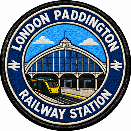Round 80mm embroidered patch showing a green passenger train beside a stylised Paddington station facade with an arched glass roof, finished with a black border.