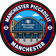Round 80mm embroidered patch showing a stylised arched Manchester Piccadilly station entrance, with white lettering on a navy ring and red trim, finished with a black border.