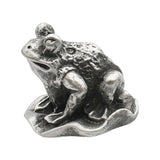 English-made pewter frog sitting on a lily pad ornament, first side view showing raised eyes and sculpted limbs