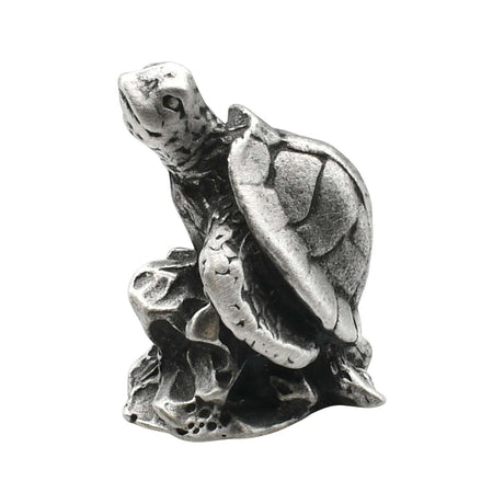 English-made pewter sea turtle on rocks figurine ornament showing raised head, textured shell and flippers on a rocky base