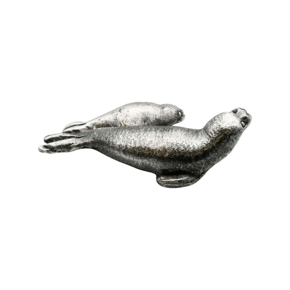 Opposite side of English-made pewter seal pup figurine featuring two seals resting together