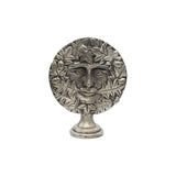 Freestanding Green Man pewter altar ornament with face surrounded by oak leaves and acorns, on display pedestal