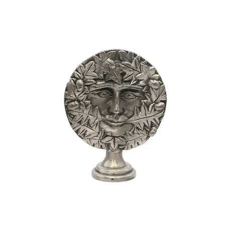 Freestanding Green Man pewter altar ornament with face surrounded by oak leaves and acorns, on display pedestal