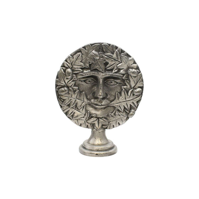 Freestanding Green Man pewter altar ornament with face surrounded by oak leaves and acorns, on display pedestal