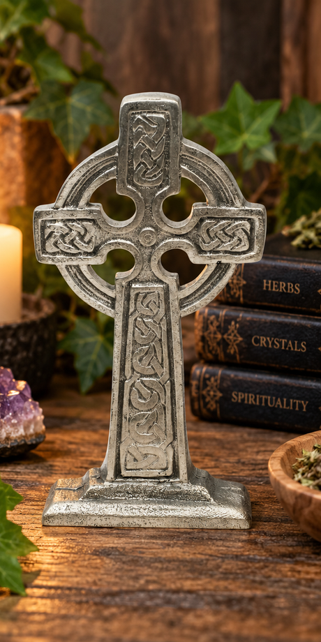 Illustrative lifestyle setting with large pewter Celtic Cross standing on rustic shelf surrounded by ivy, books and candle, without a gift bag