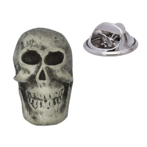 Antique silver-coloured skull lapel pin badge showing eye sockets, teeth and butterfly clasp