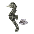 Antique silver-coloured seahorse lapel pin with curled tail, textured body and butterfly clasp
