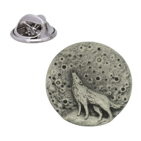 Circular pewter lapel pin showing a howling wolf silhouetted against a cratered full moon, with butterfly clasp